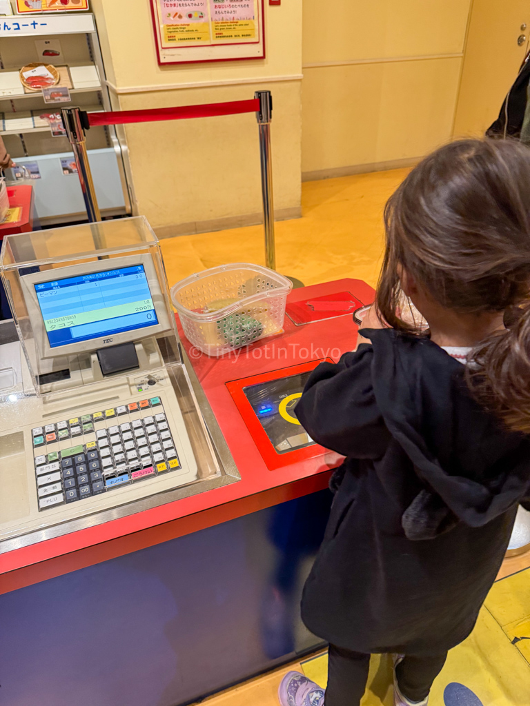 a child using the register at kids plaza osaka