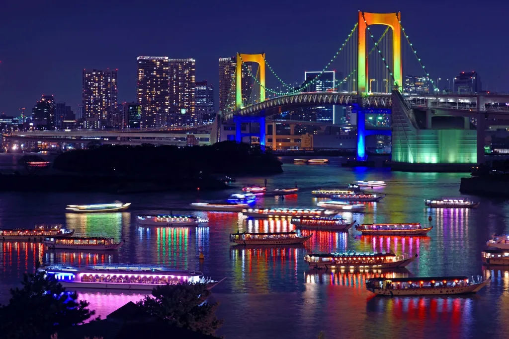 Colorful Odaiba bridge and Skyline at night in Tokyo with lots of boats in the river