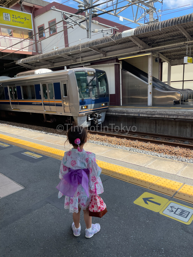 girl in a yukata waiting for a train to go to a natsumatsuri in Japan