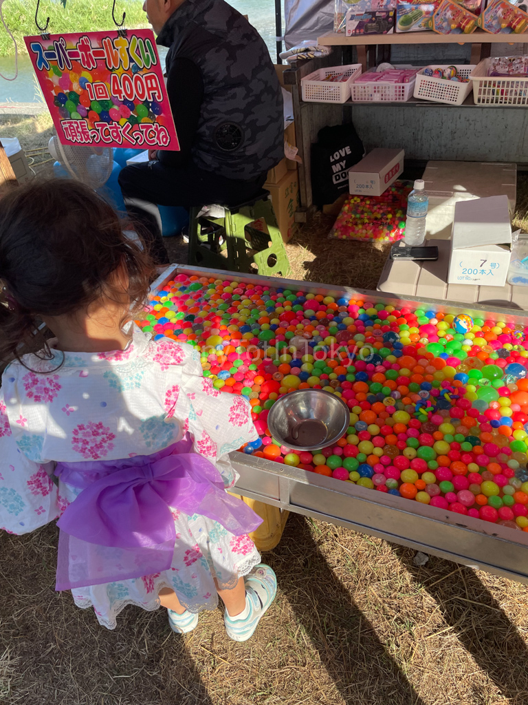 girl in yukata playing a game at a summer festival in japan