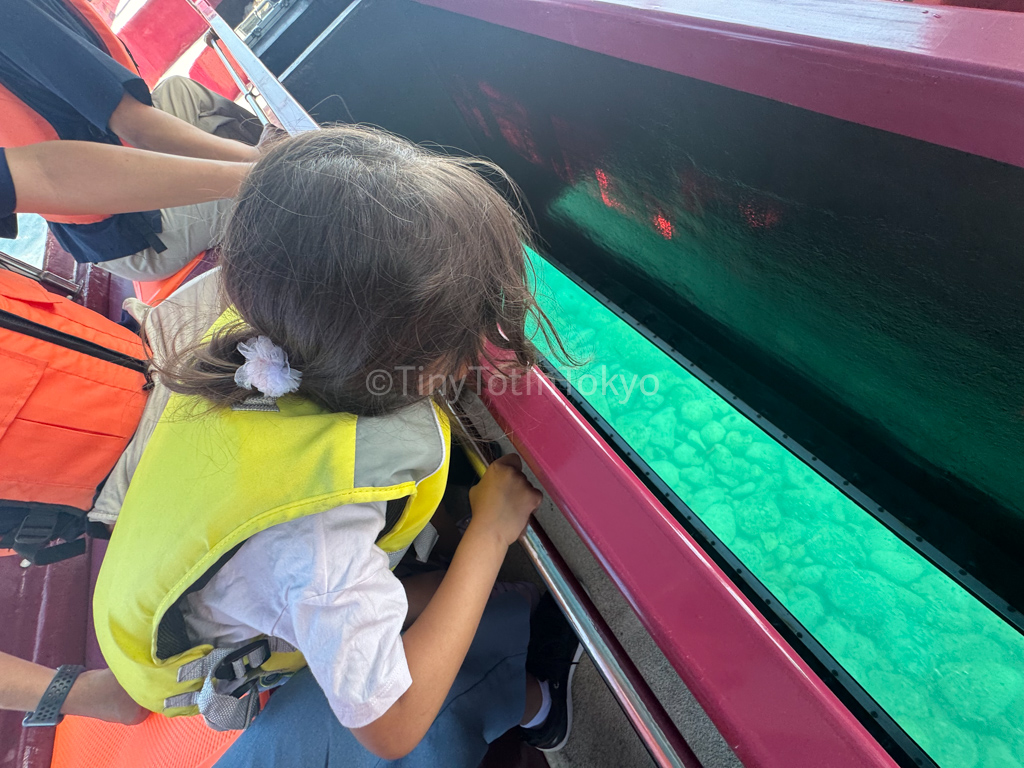 Kid looking down in glass boat in Otaru Hokkaido