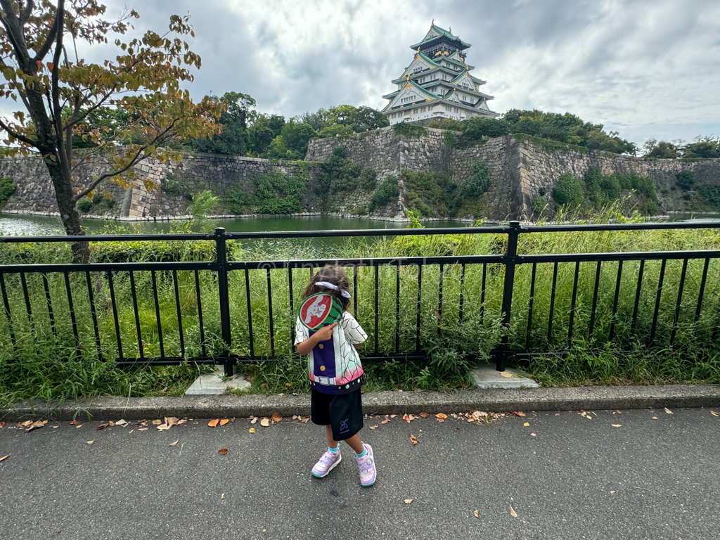 Child standing in front of Osaka Castle