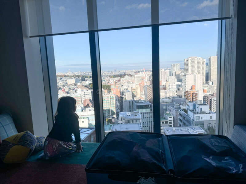 a child looking out at tokyo city from omo5 hotel