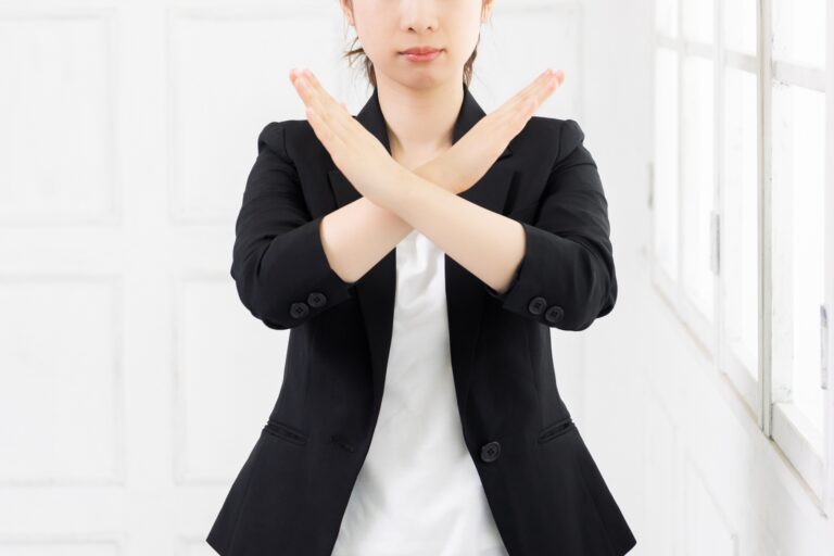 a woman in Japan wearing a black jacket and white shirt crossing her arms