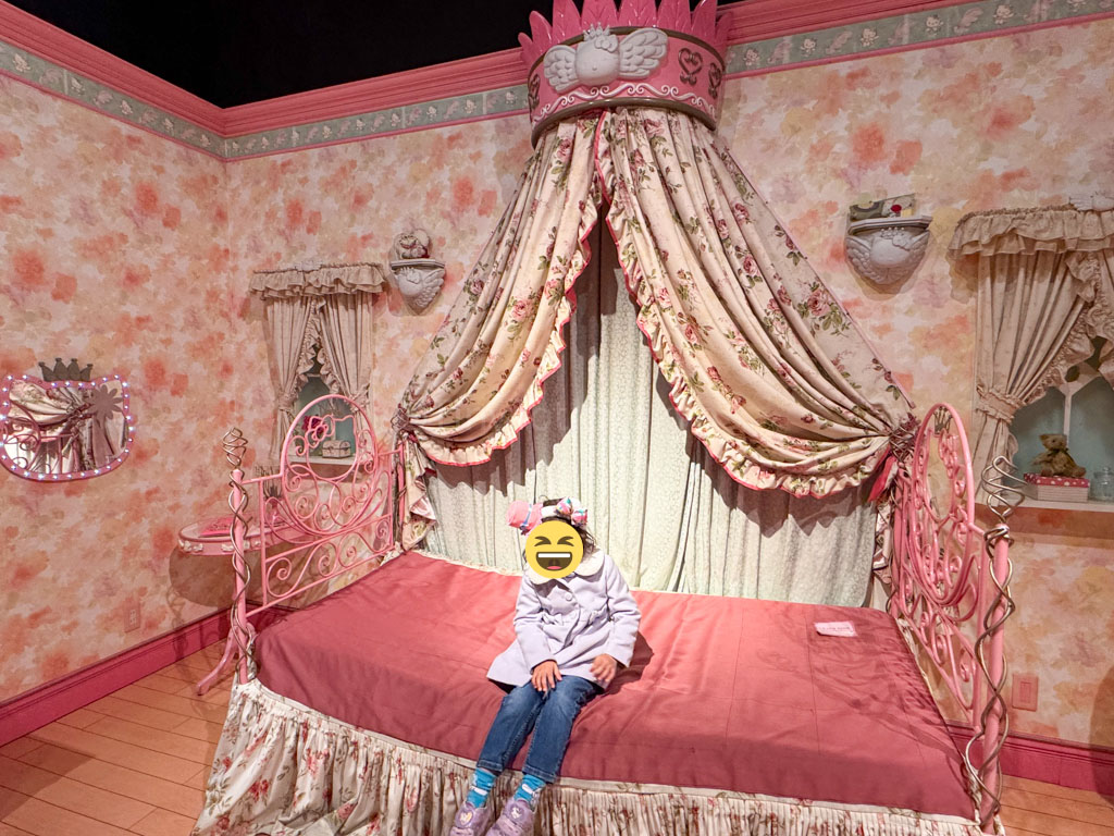 A girl sitting on a hello kitty bed at Harmonyland
