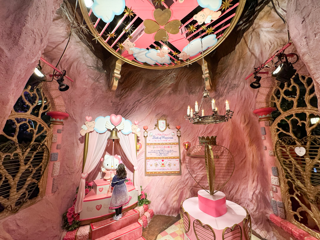 A child ringing the bell of happiness at sanrio puroland