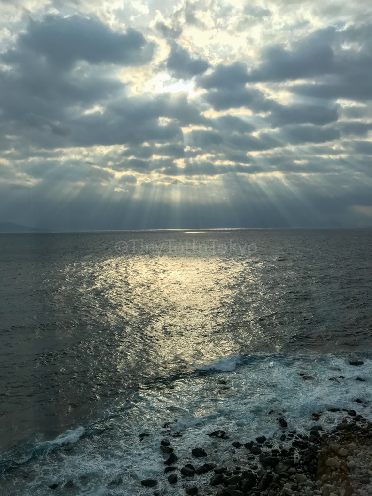 an ocean with sunlight streaming from clouds, a heavenly image that reminds me of loss and life