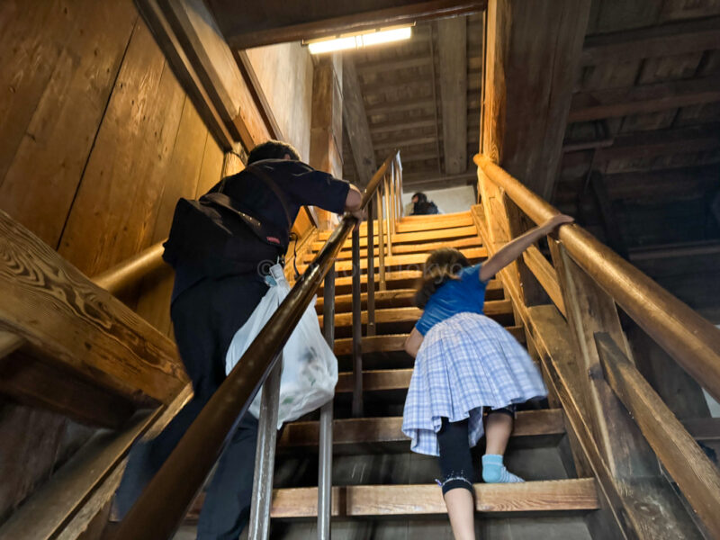 A father and child going up a flight of stairs at himeji castle