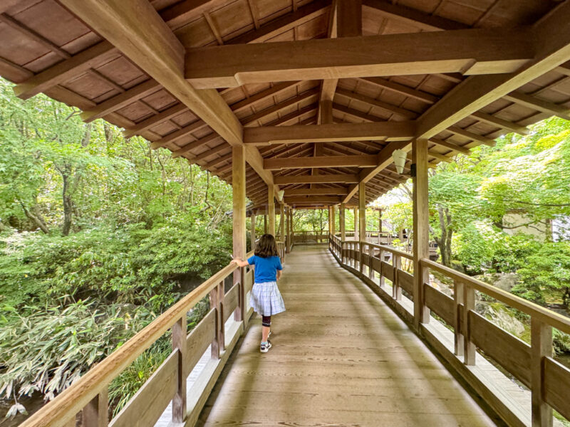 A child walking through the Cho-on sai guest house and roofed corridor.