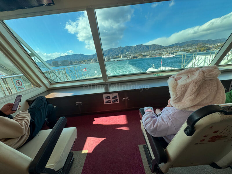 A child sitting inside the ferry for Miyajima