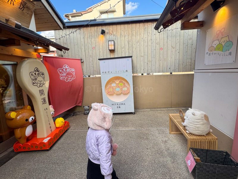a child in front of the rilakumma store and sumikko store in Miyajima