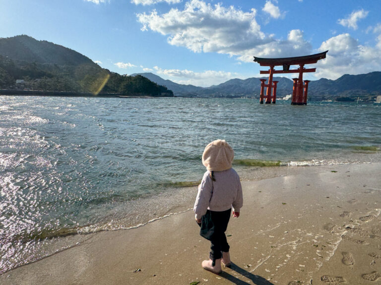 A child in Miyajima looking at the Grand Torii Gate