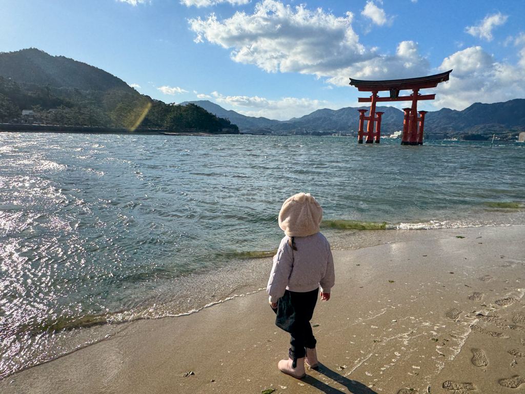 A child in Miyajima looking at the Grand Torii Gate