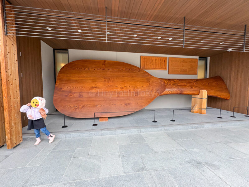 A child and a giant rice paddle in Miyajima