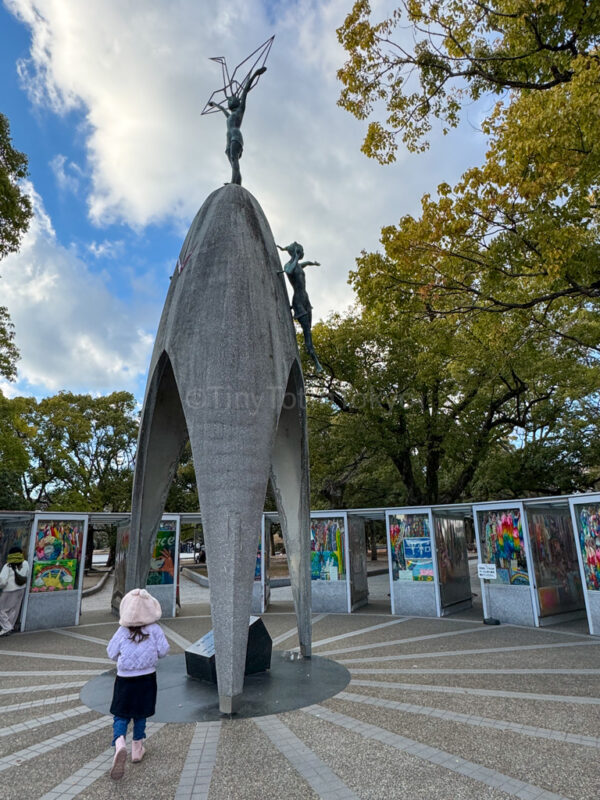 A child standing in front of the Children's Peace Monument in Hiroshima