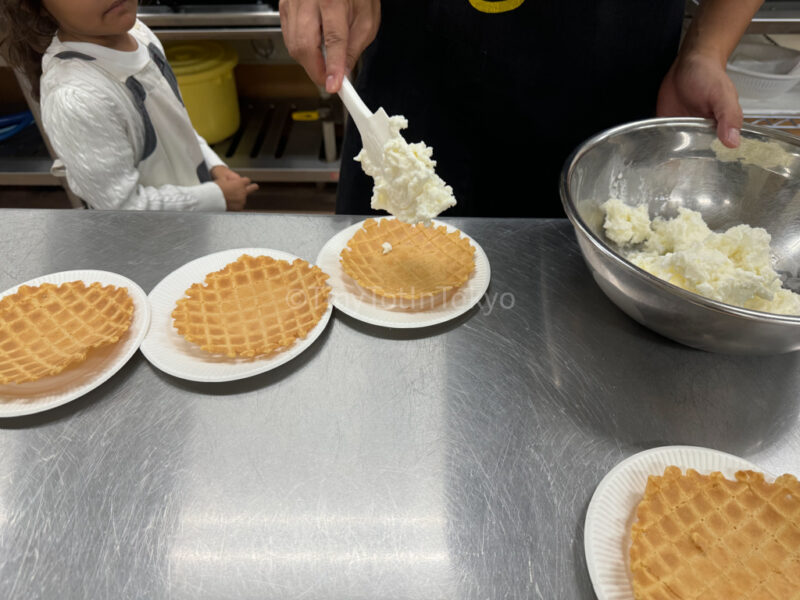 Putting ice cream on the waffle bowl at furano cheese factory