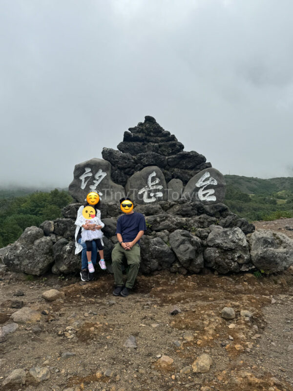 a family sitting on Tokachidake Observatory