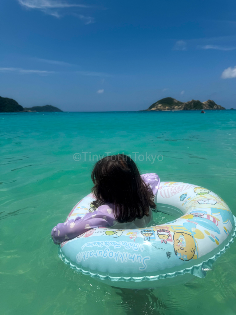 a child in a swim ring swimming in Okinawa