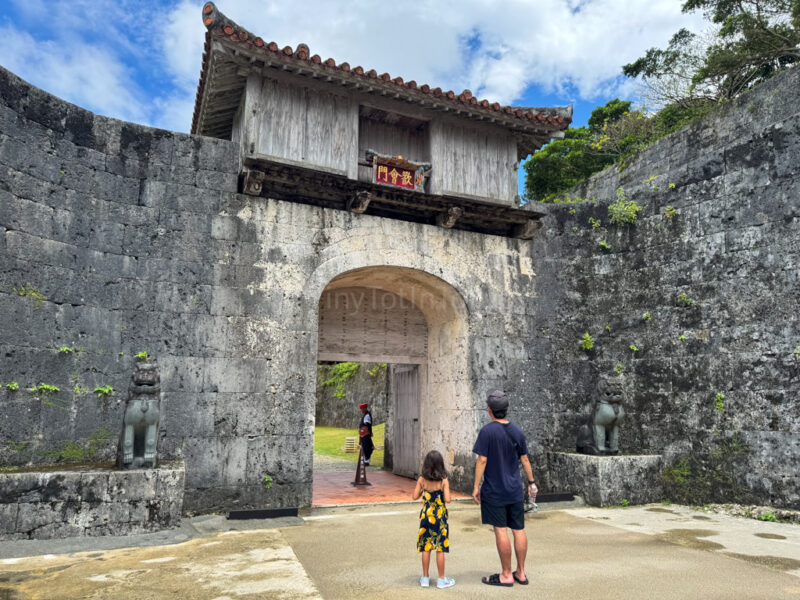 a child and parent walking to the entrance of Shuri Caste in OKinawa