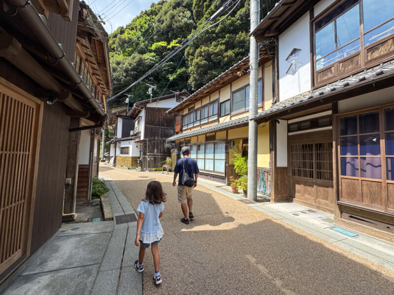 a parent and child walking in ine village 