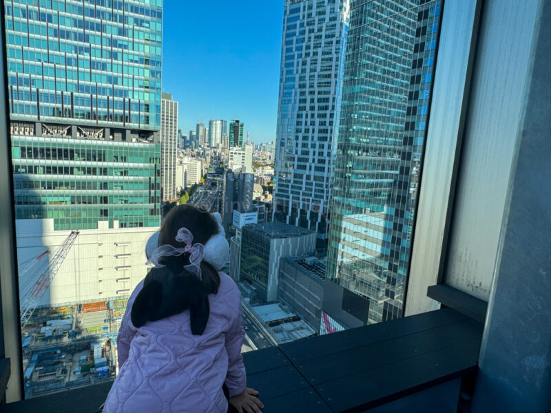 A child looking out at Shibuya's Skyline