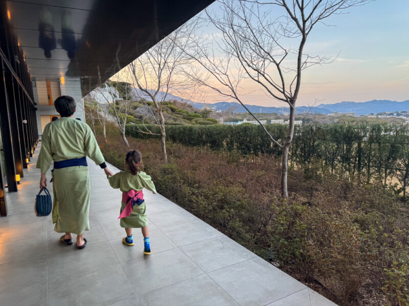 a child and parent walking in Suginoi Hotel in Beppu