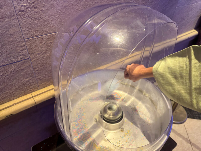 a child making cotton candy at suginoi hotel beppu