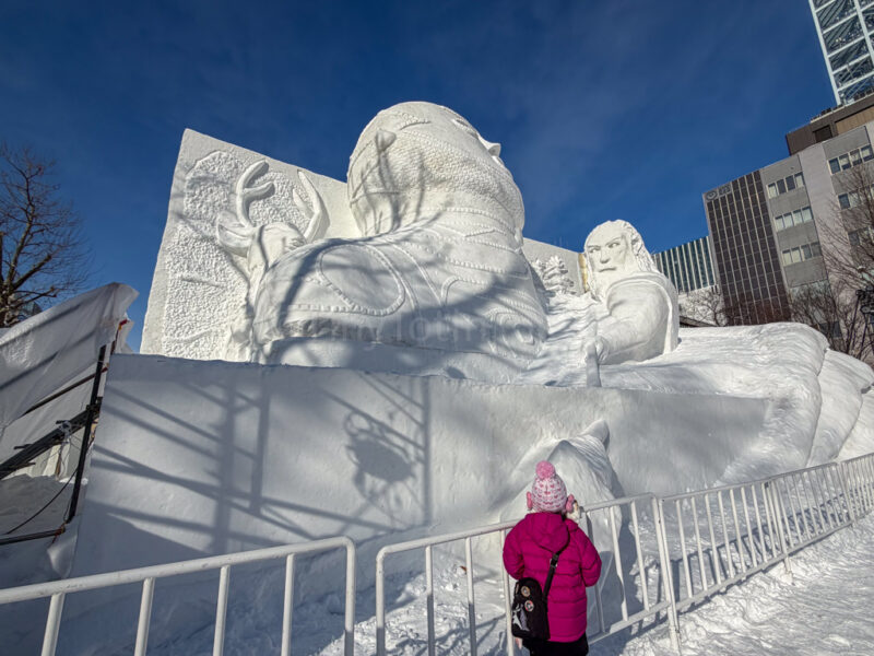 child in front of Jomon art at sapporo snow festival