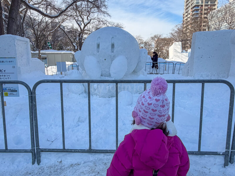a child in front of a kirby statue at sapporo snow festival