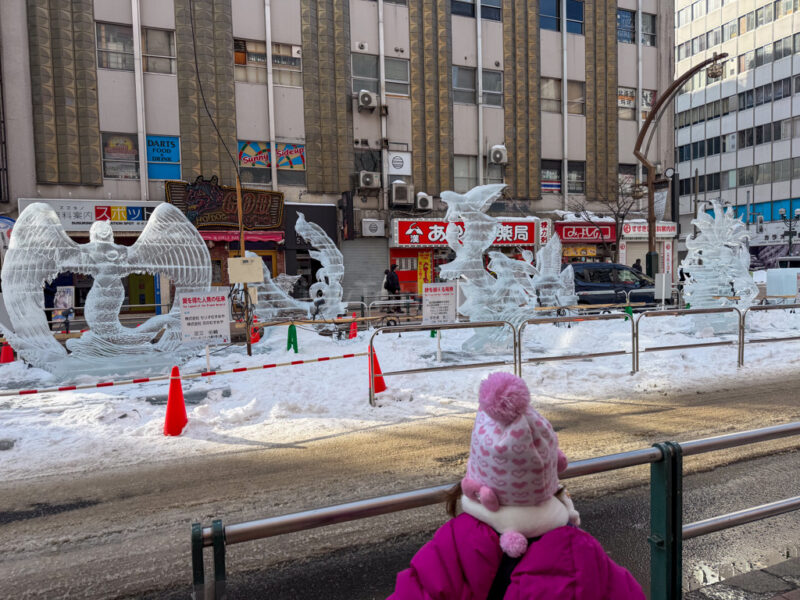 a child looking at ice sculptures at the susukino Sapporo Snow Festival