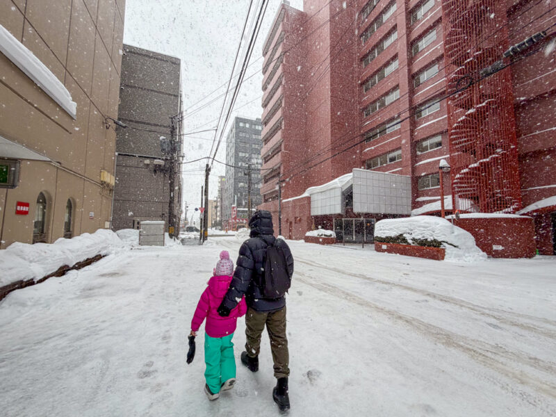 a child and parent walking in sapporo in winter