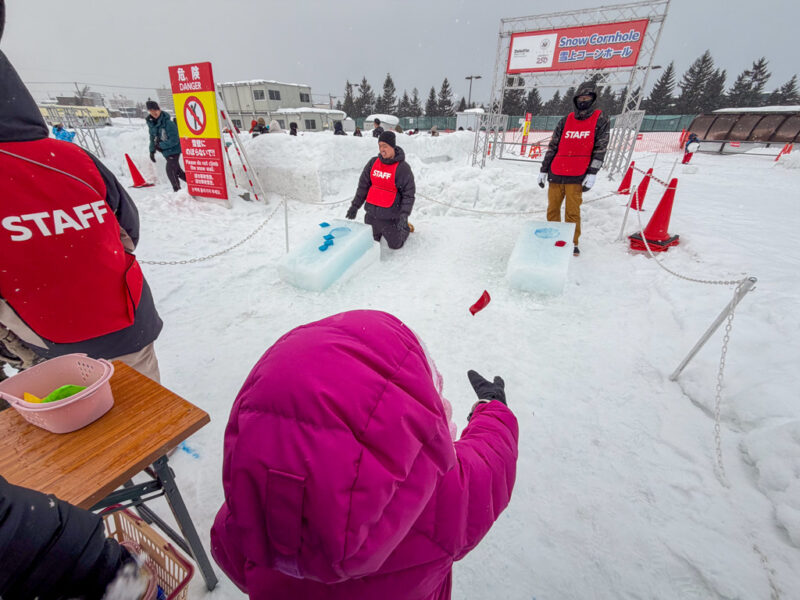 a child throwing beanbags at tsudome site of sapporo snow festival