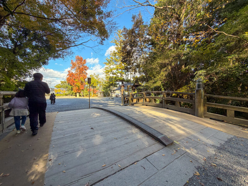 a parent and child walking on a bridge in ise jingu geku