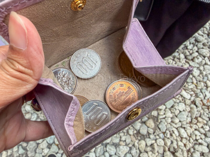a wallet with Japanese coins in it