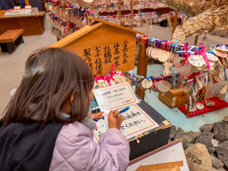 A child writing a wish at Toba Sea folk Museum