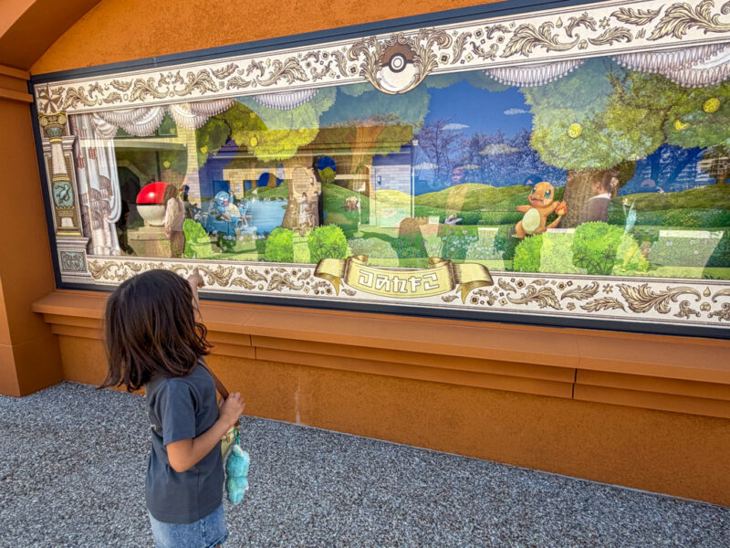 child looking at display in front of pokemon daisuki shop at pokepark kanto