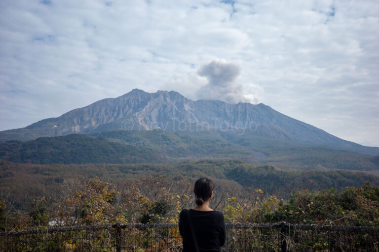 the author standing in front of Sakurajima in Kagoshima