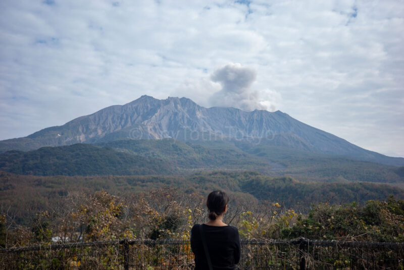 the author standing in front of Sakurajima in Kagoshima