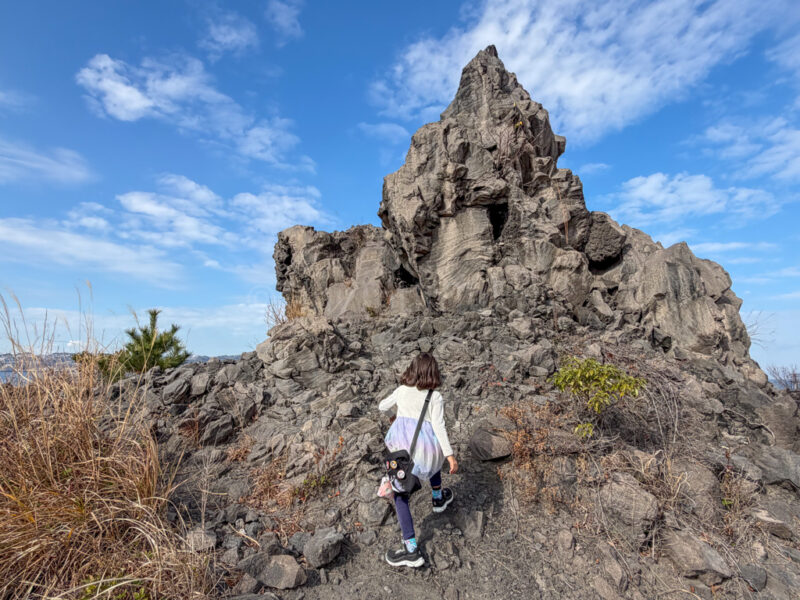 a child climbing a volcanic formation at yogan nagisa trail in sakurajima