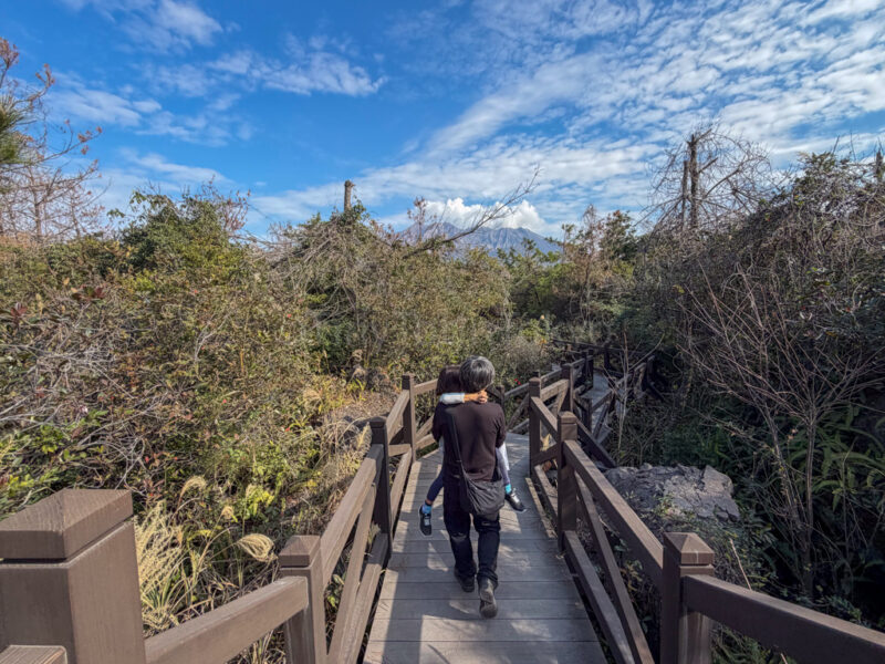 a parent carrying a child on yogan nagisa trail in sakurajima