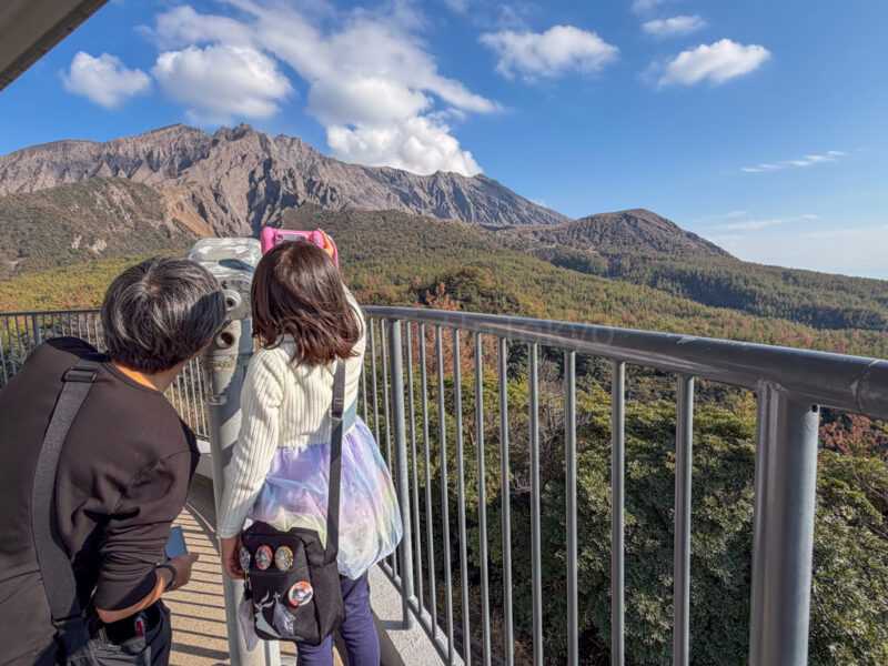 a parent and child using binoculars at Yunohira Observation Deck in sakurajima