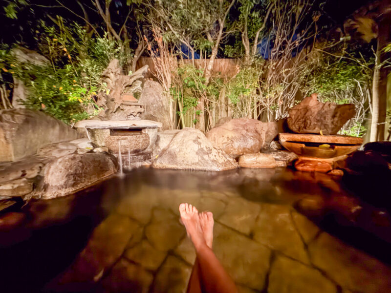 author's legs in a private onsen bath at Shikinoyado Meisui ryokan in Kagoshima