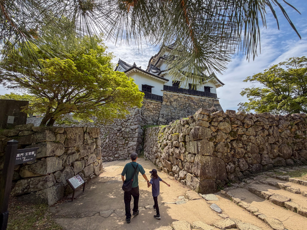 a parent and child in front of Hikone Castle in Shiga
