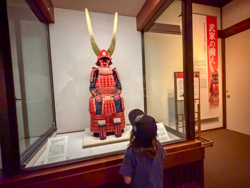 a child looking at red samurai armor at hikone castle museum 