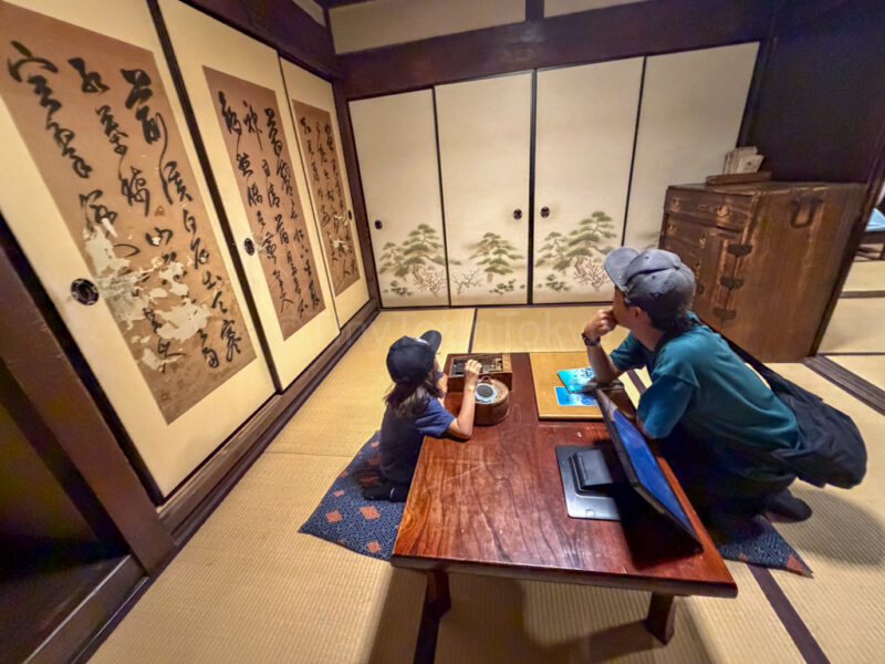 a parent and child sitting in an edo period room at Lake Biwa Museum