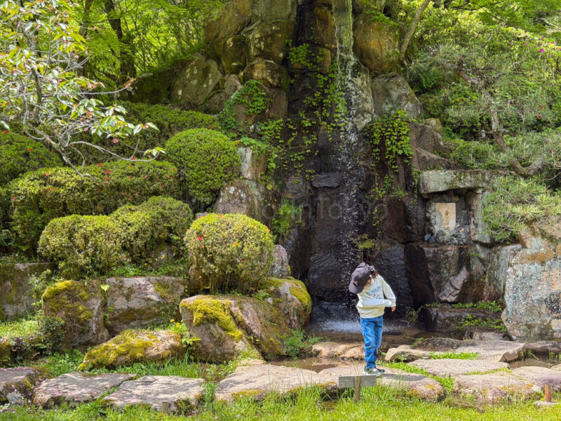 A child near a waterfall at Ishiyamadera in Shiga