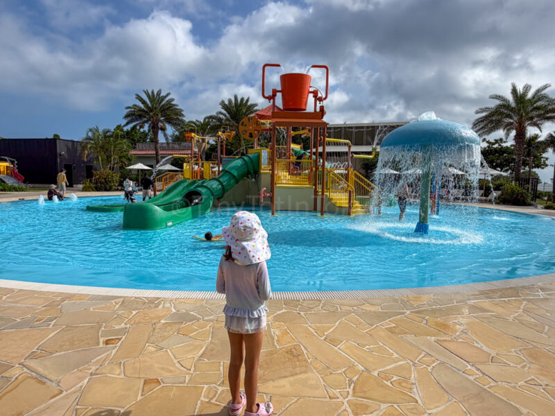 child in front of splash pad at fusaki beach resort ishigaki