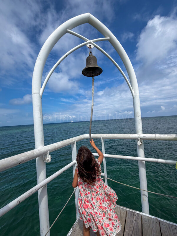child ringing bell at angel pier fusaki beach resort ishigaki