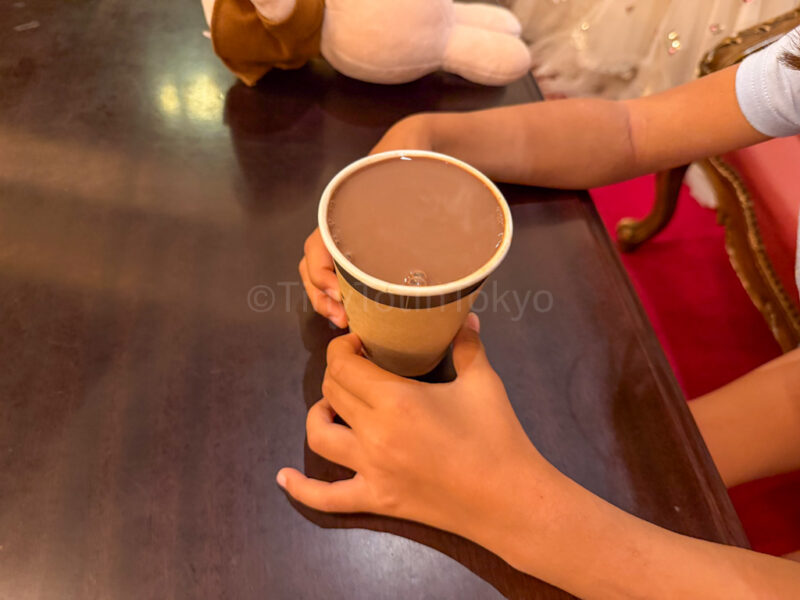 a child holding a cold chocolate drink at huis ten bosch