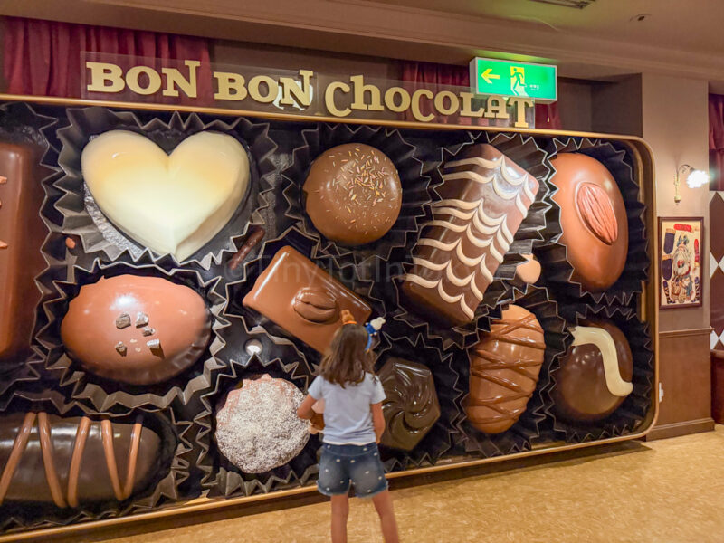 a child posing in front of chocolate at huis ten bosch